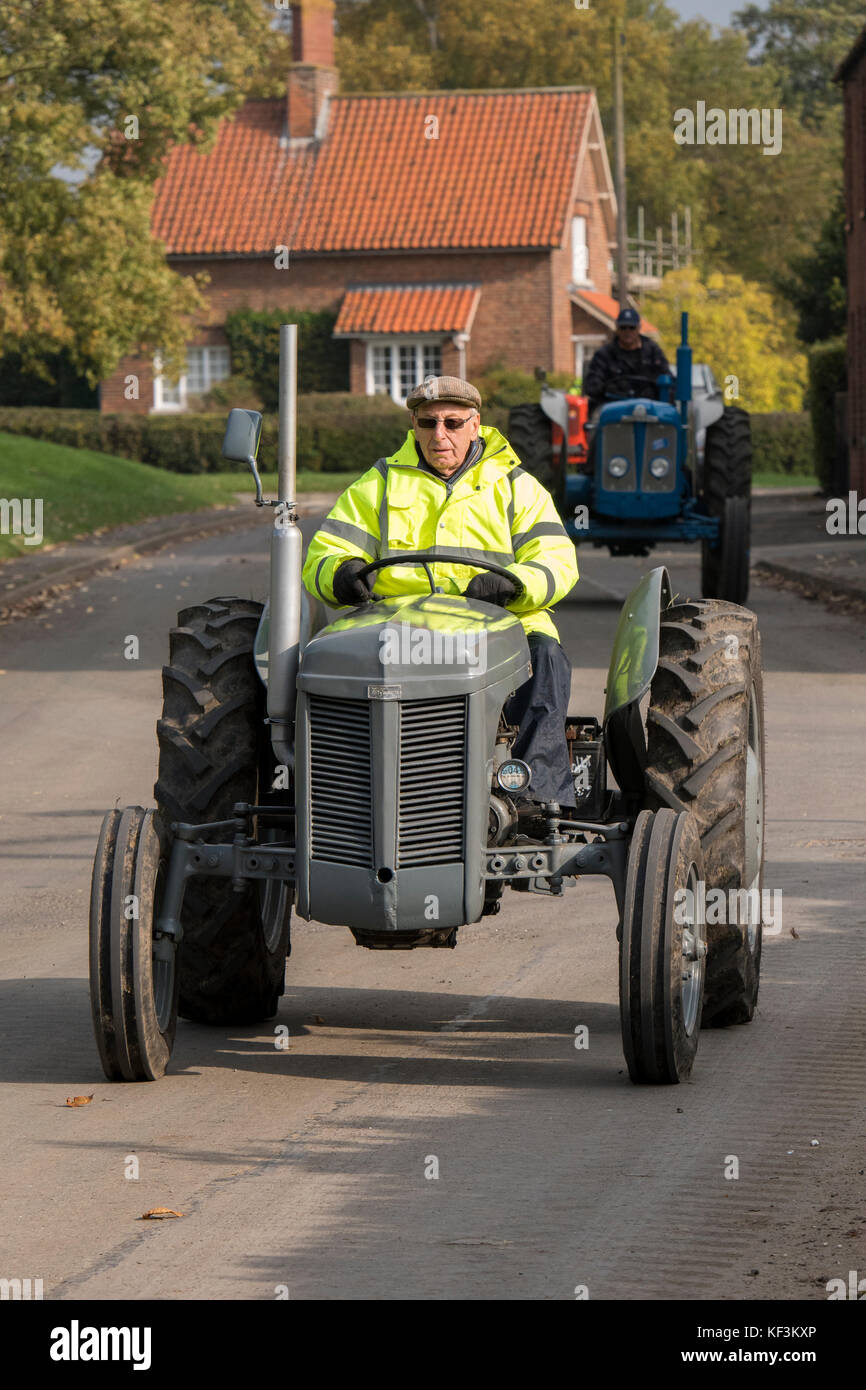 Man driving grey vintage tractor in parade through Bugthorpe village for annual charity event