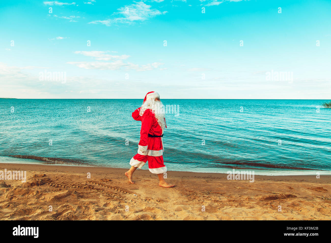 Santa Claus with a bag of gifts on the beach. The symbol of Christmas ...