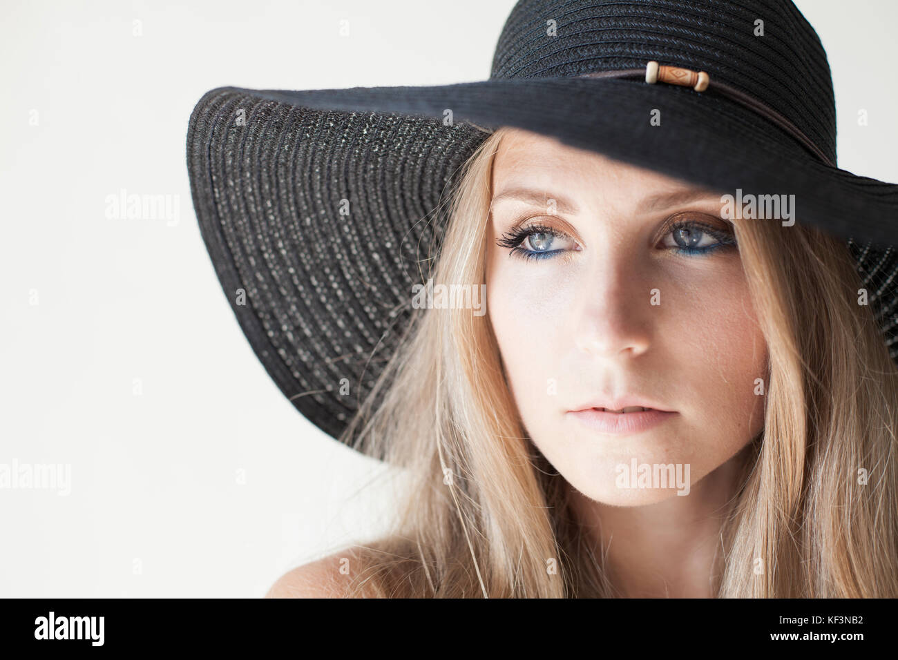 fashionable girl in a hat with a brim poses for advertising Stock Photo