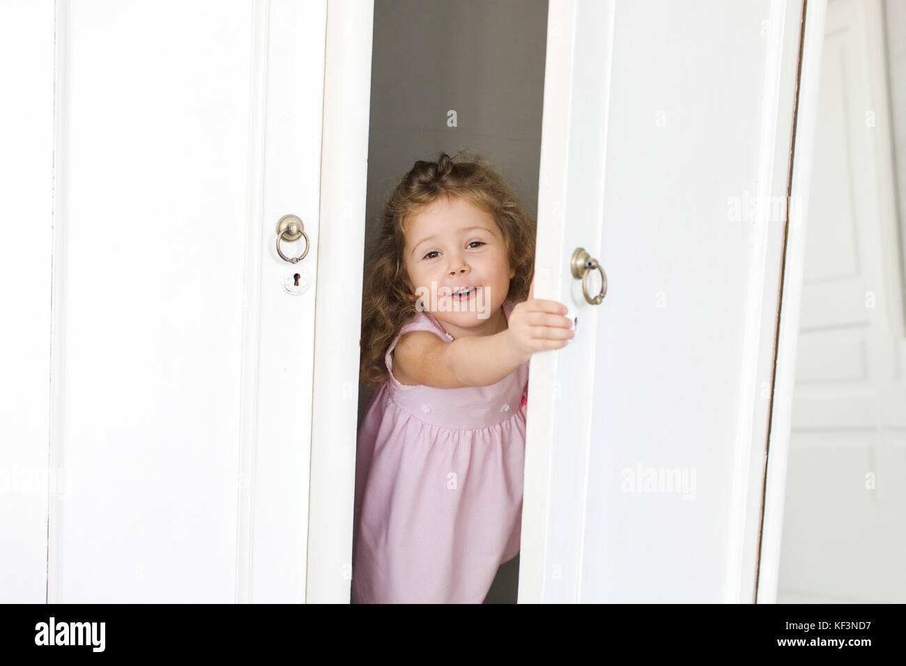 Cute girl in closet smiles Stock Photo