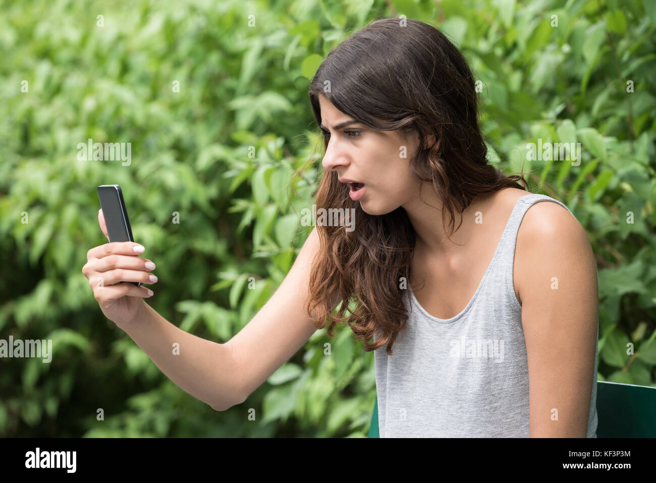 Close-up Of Frustrated Young Woman Looking At Mobile Phone Stock Photo