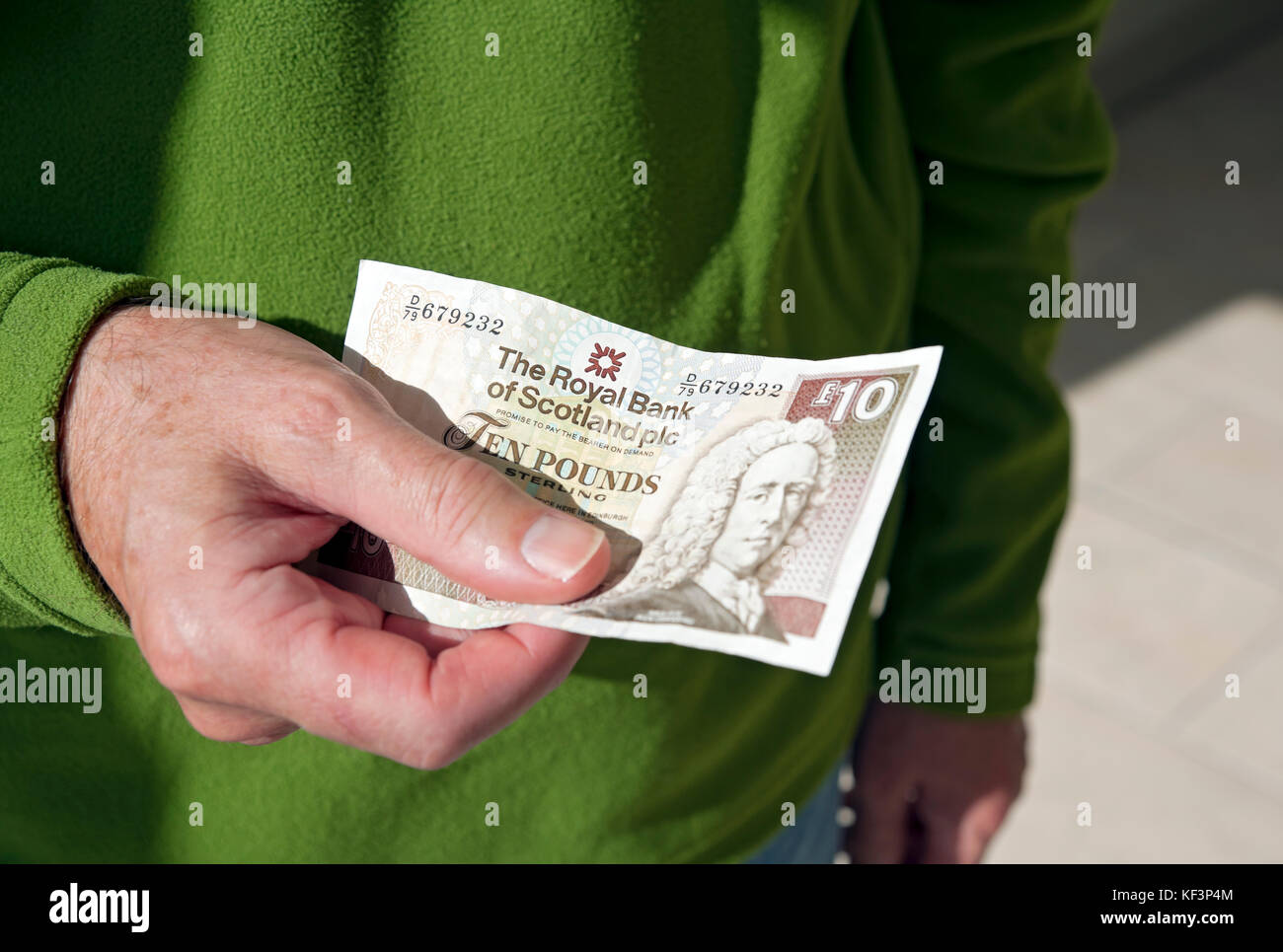Close up of man person holding Scottish ten pound pounds note £10 money banknote banknotes cash UK United Kingdom GB Great Britain Stock Photo
