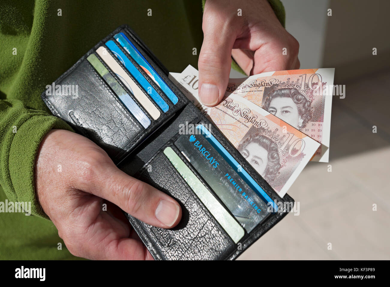 close up of man person taking new 10 ten pound notes english money KF3P89