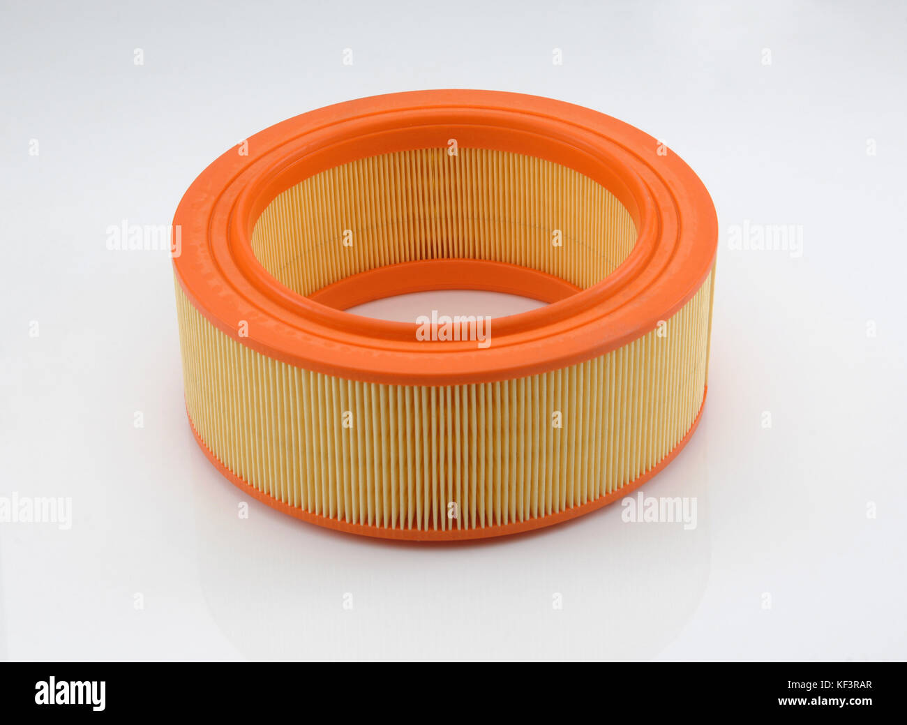 automotive filter cylindrical shape of orange color on a white ...