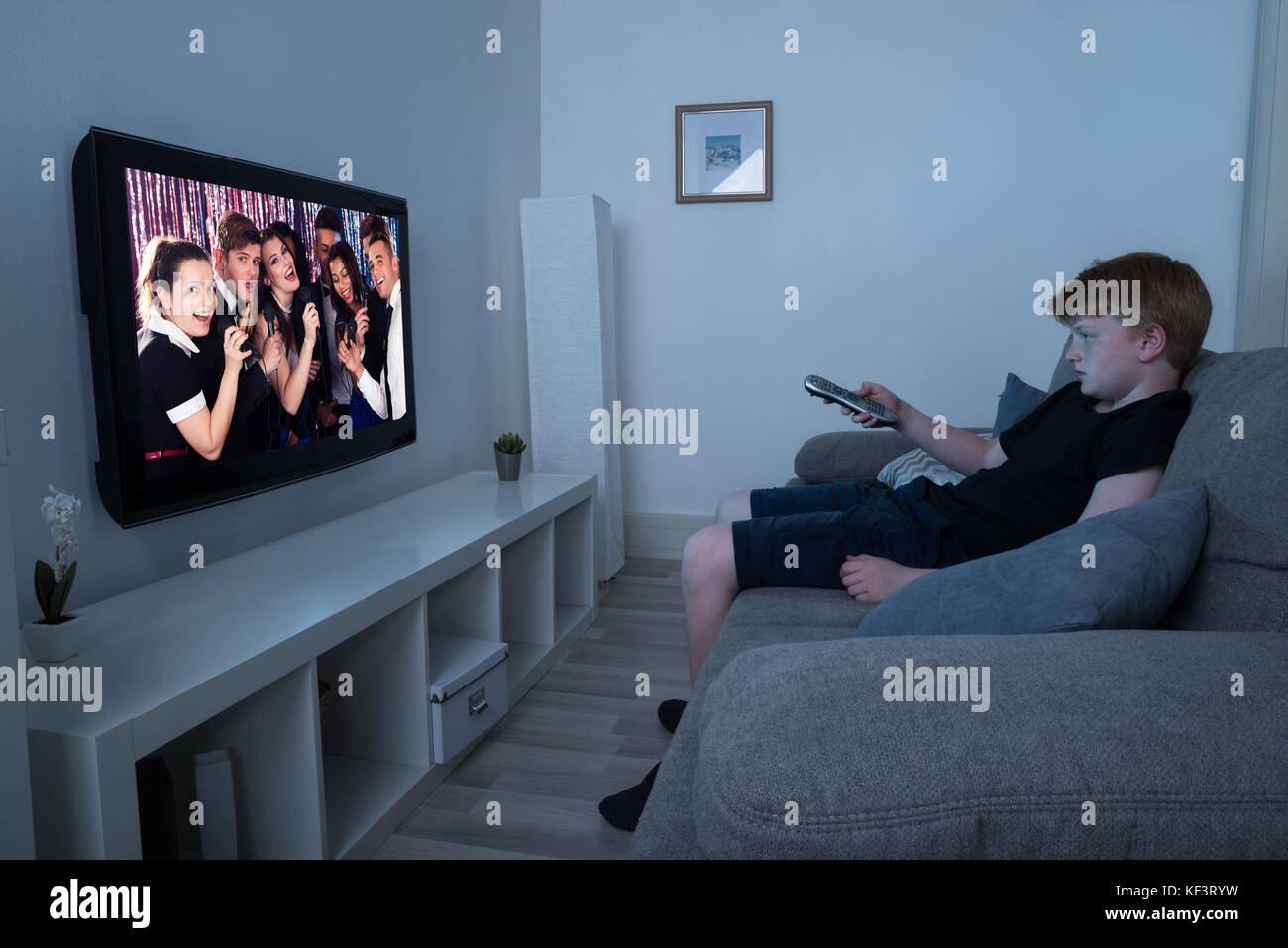 Boy Sitting On Sofa Watching Television At Home Stock Photo Alamy
