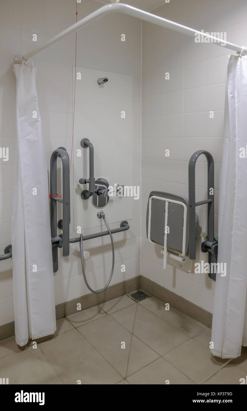 Disabled shower cubical in changing room. Vertical shot showing seat and railings. Stock Photo