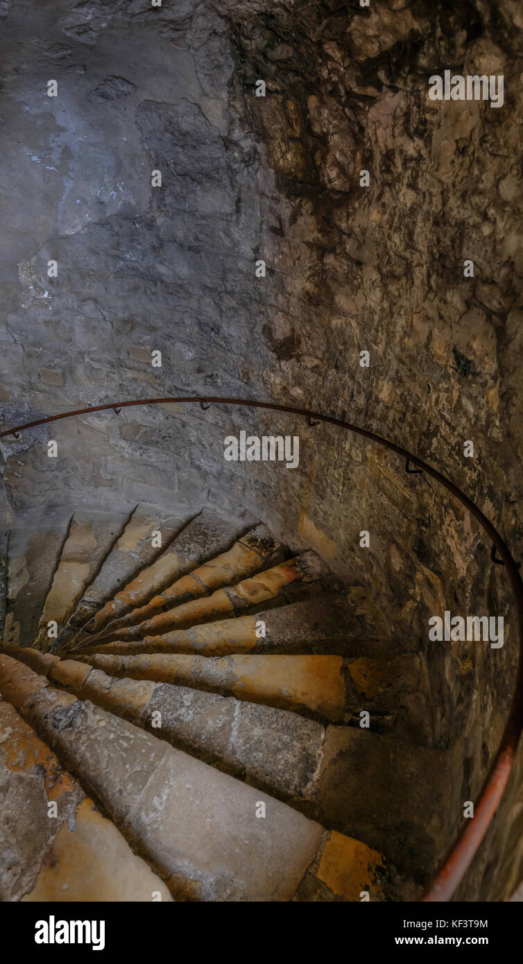 Dungeon spiral staircase, going down. Shows beautifully lit old steps. Stock Photo
