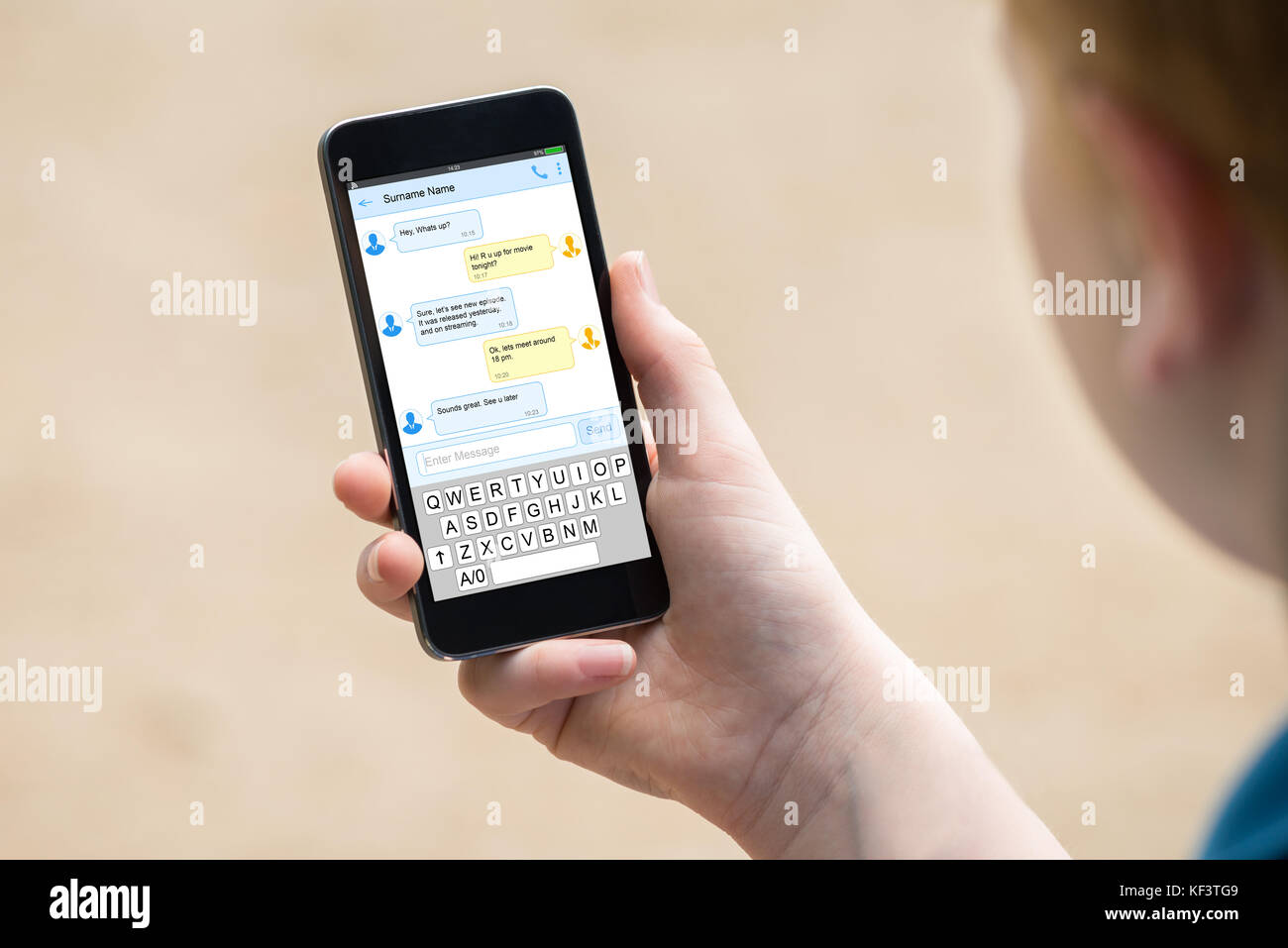 Boy's Hand Holding Mobile Phone With Messages On Screen Stock Photo