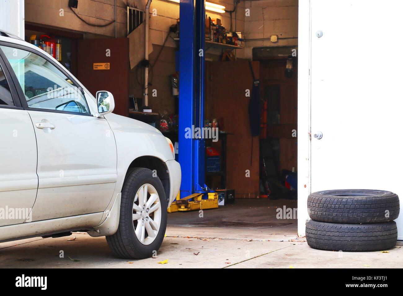 Car waiting for check up in front of small auto service shop. Car repair and service background. Stock Photo