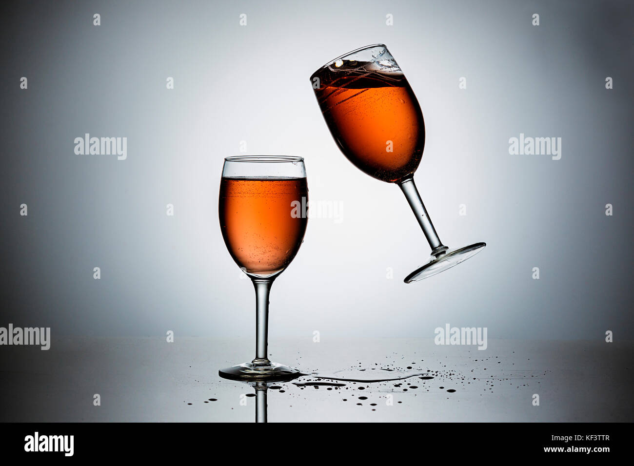 Dropping a wineglass filled with wine onto another. Stock Photo