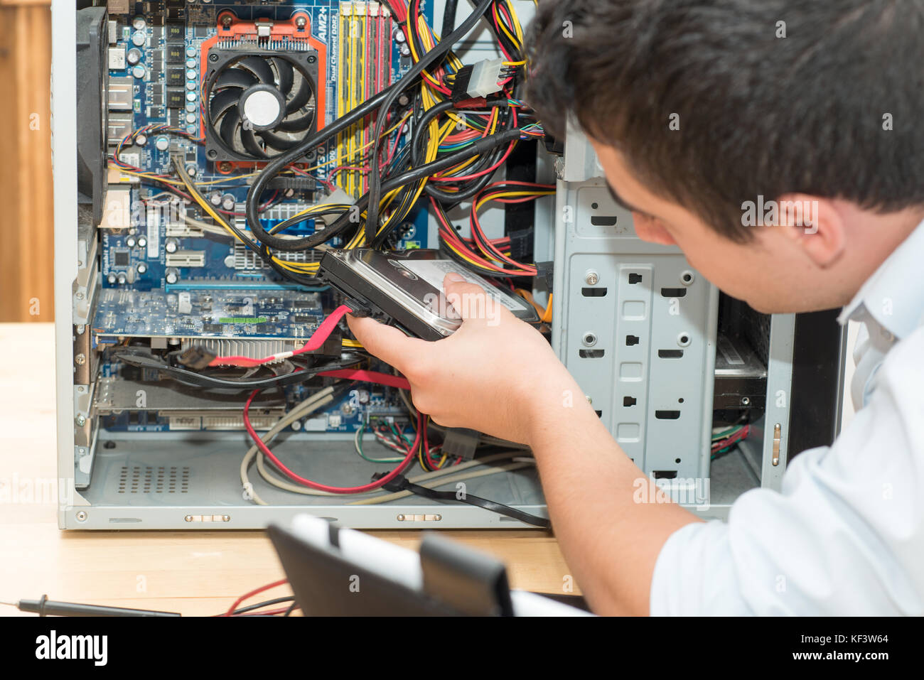 a young technician working on broken computer in his office Stock Photo ...