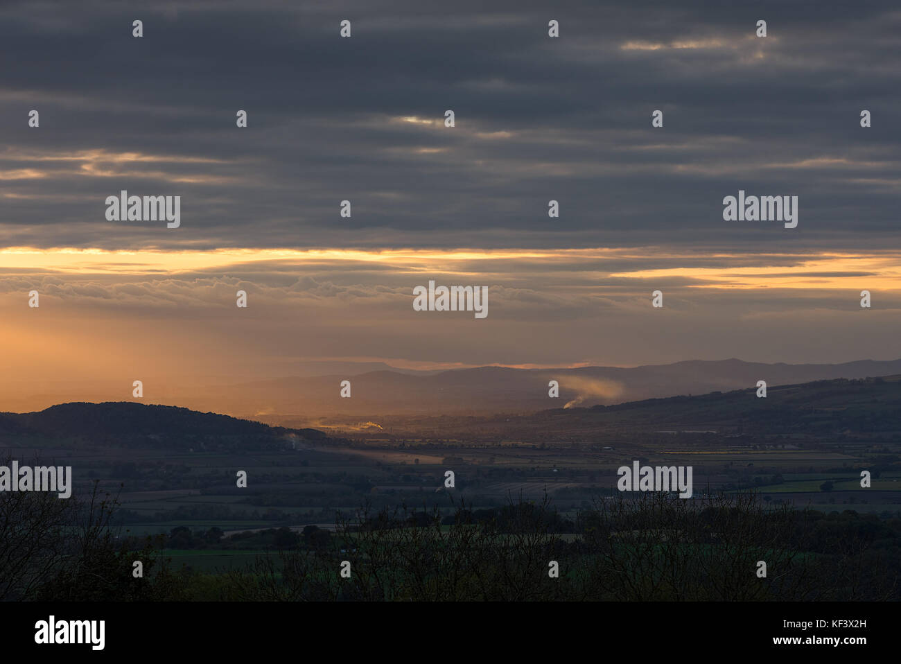 A golden hour view from Broadway Tower across the British countryside cotswold towards the Malvern Hills. Stock Photo