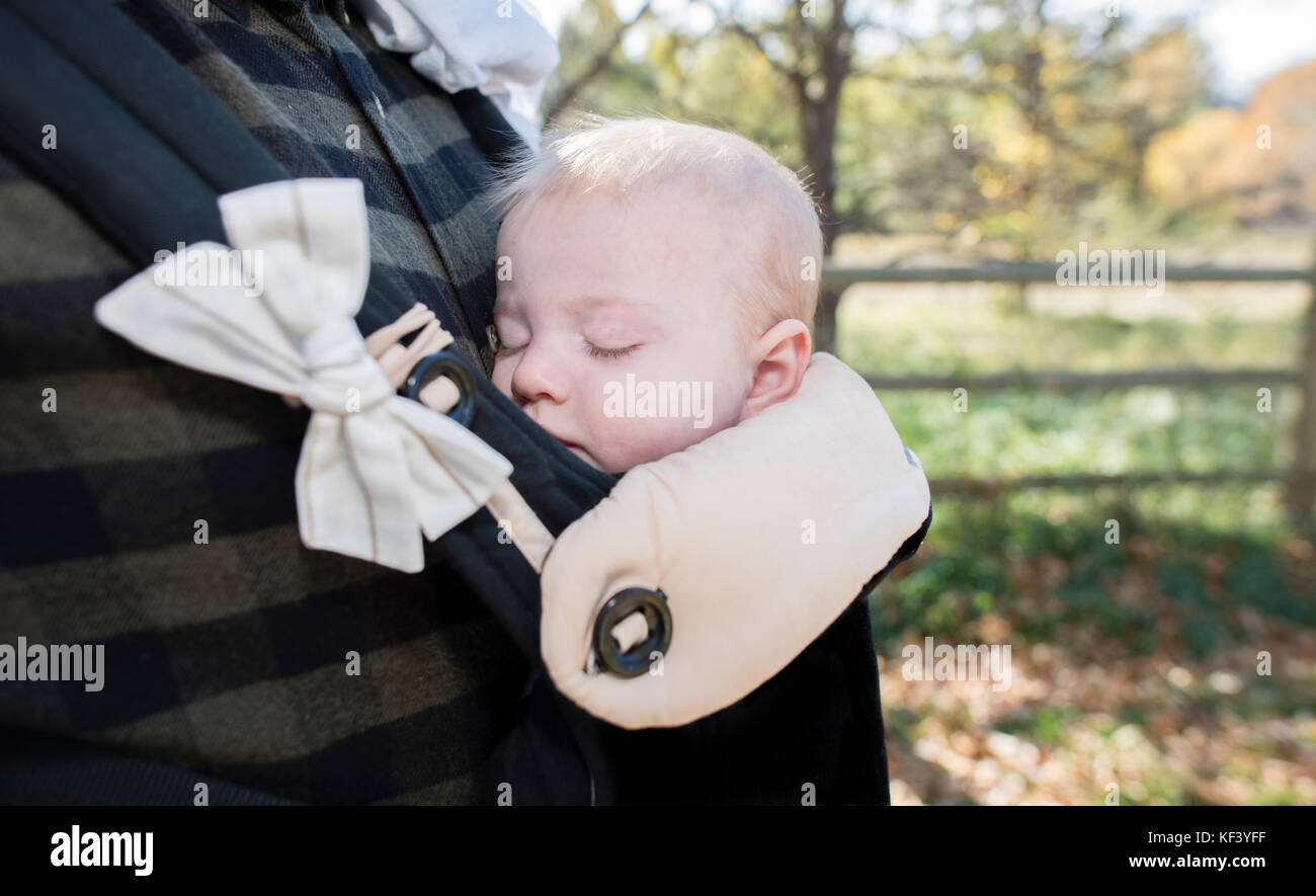 Blond Baby Girl Asleep in Carrier on Dad's Chest Outside on a Beautiful