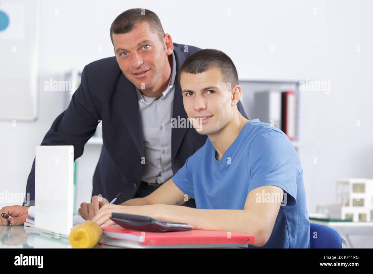 professor assisting a student with studies in college library Stock ...