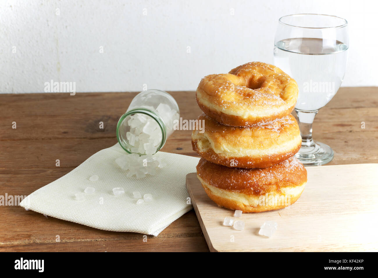 donuts glazed with a sugar icing on a rustic wooden table Stock Photo