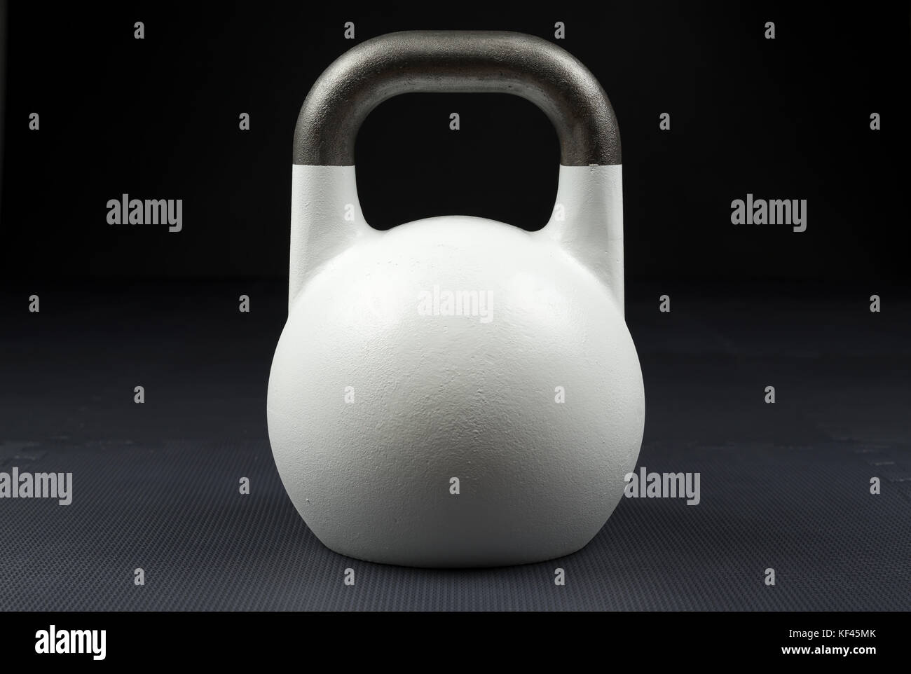 White 10kg competition kettlebell on the floor of a weight training gym Stock Photo