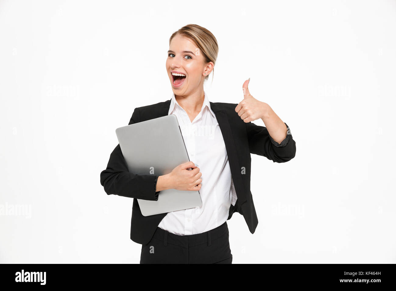 Happy blonde business woman holding laptop computer and showing thumb ...