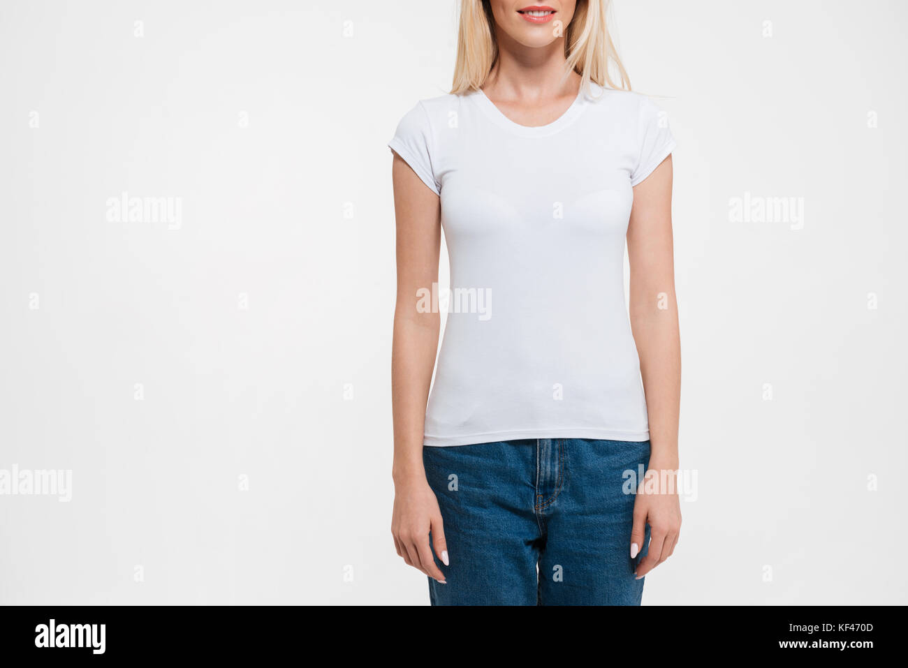 Cropped image of a blonde woman in t-shirt and jeans standing still  isolated over white background Stock Photo - Alamy