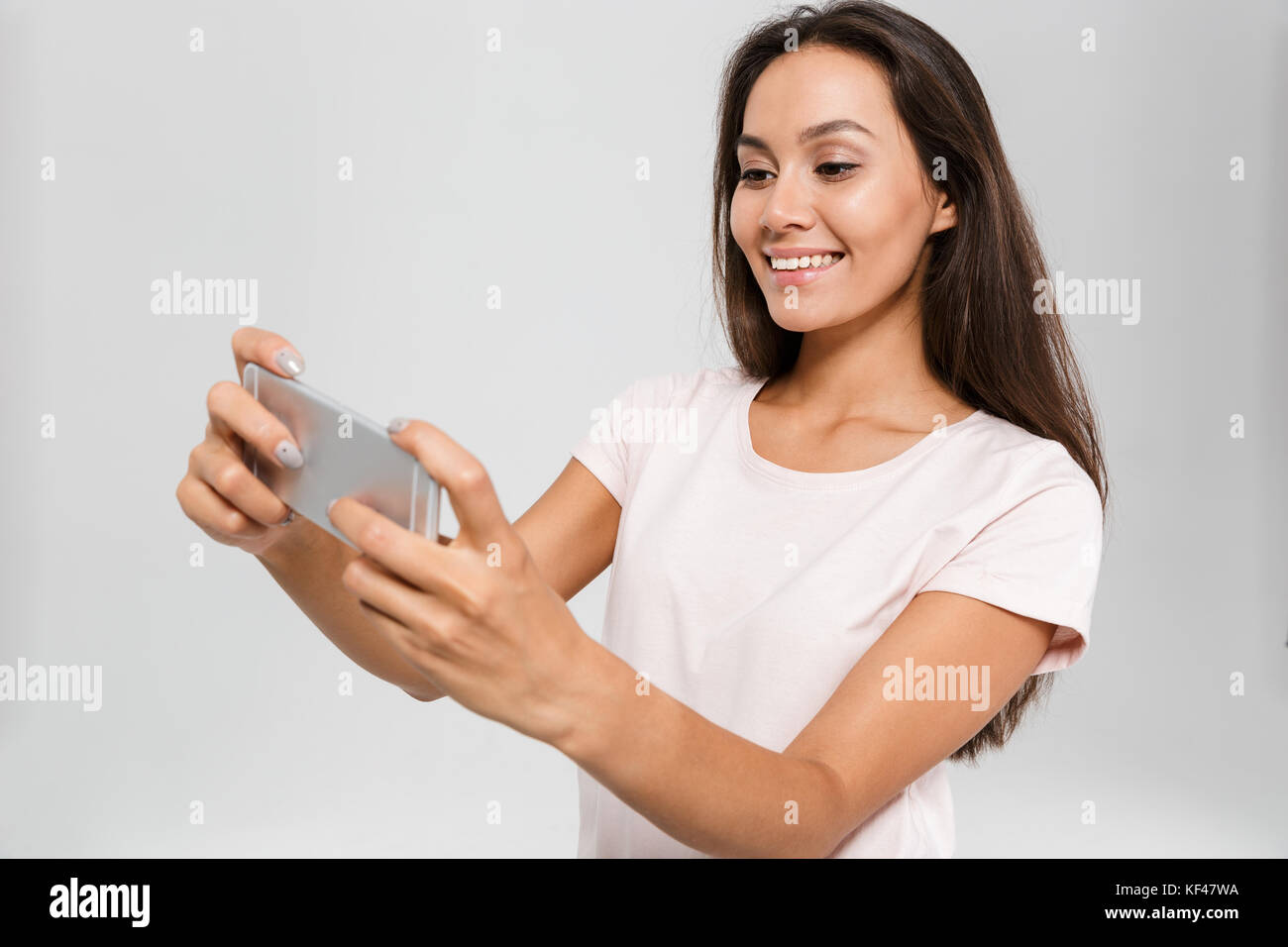 sexy Asian woman play game online on smartphone and smile Stock Photo