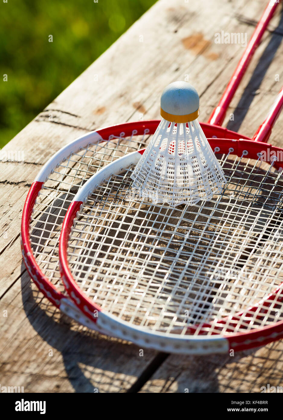 Badminton racquets with shuttlecock on a bench Stock Photo Alamy