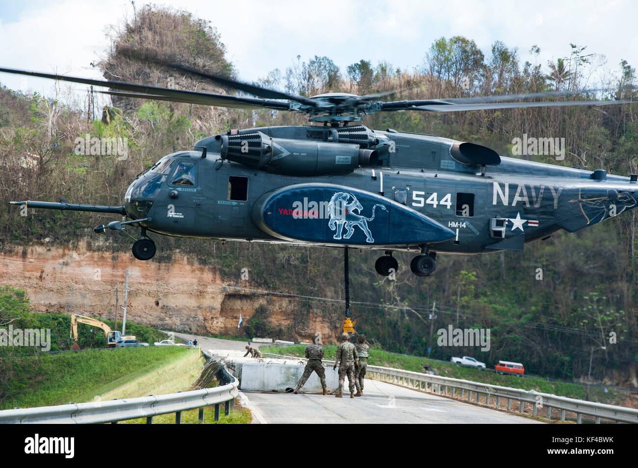 A U.S. Navy MH-53E Sea Dragon helicopter transports concrete barriers to  repair the Guajataca Dam during relief efforts in the aftermath of  Hurricane Maria October 7, 2017 in Quebradillas, Puerto Rico Stock