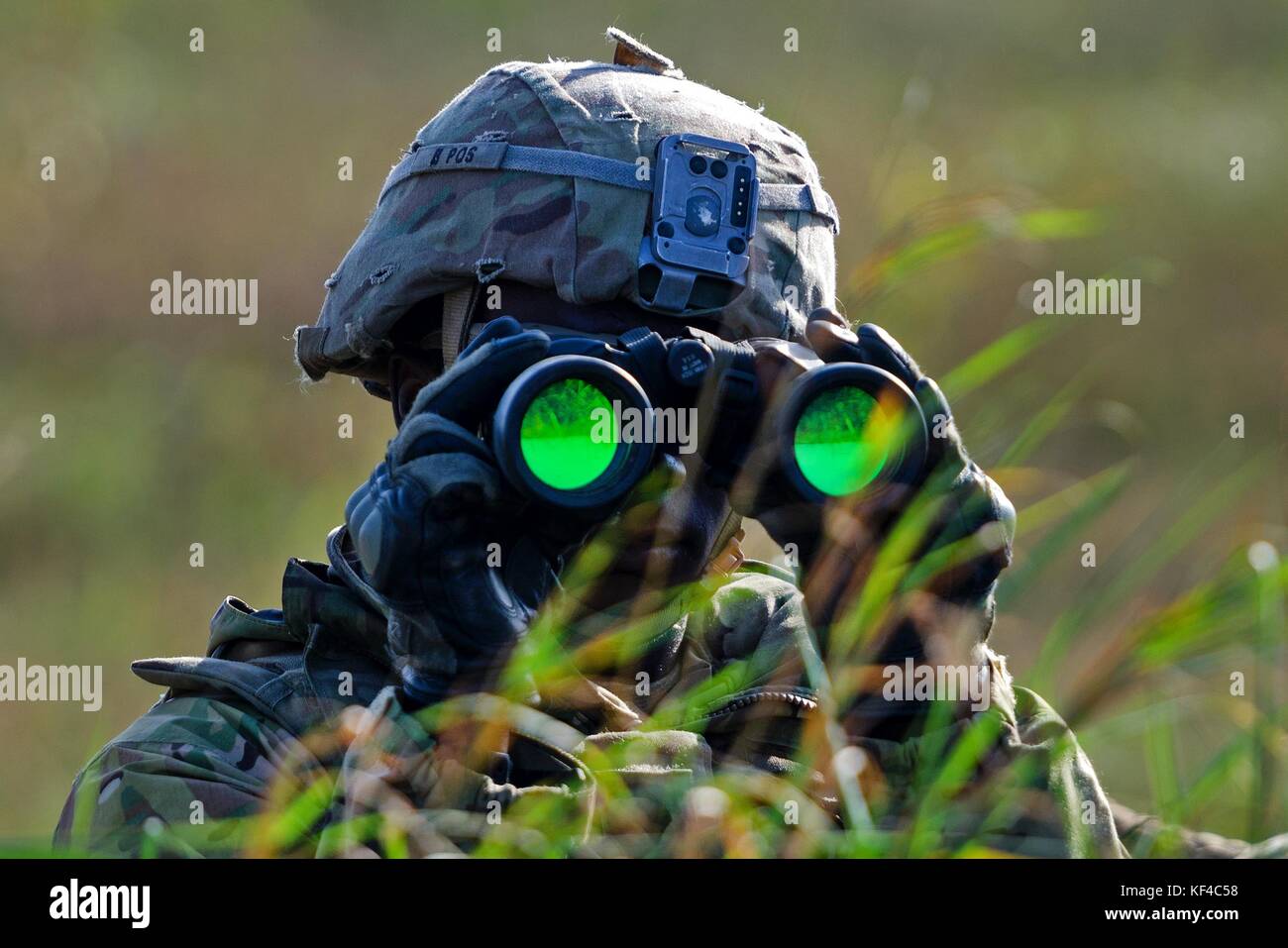 A U.S. Army soldier scans the horizon with binoculars during exercise Dragon at the Bemowo Piskie Training Area September 26, 2017 near Orzysz, Poland. Stock Photo