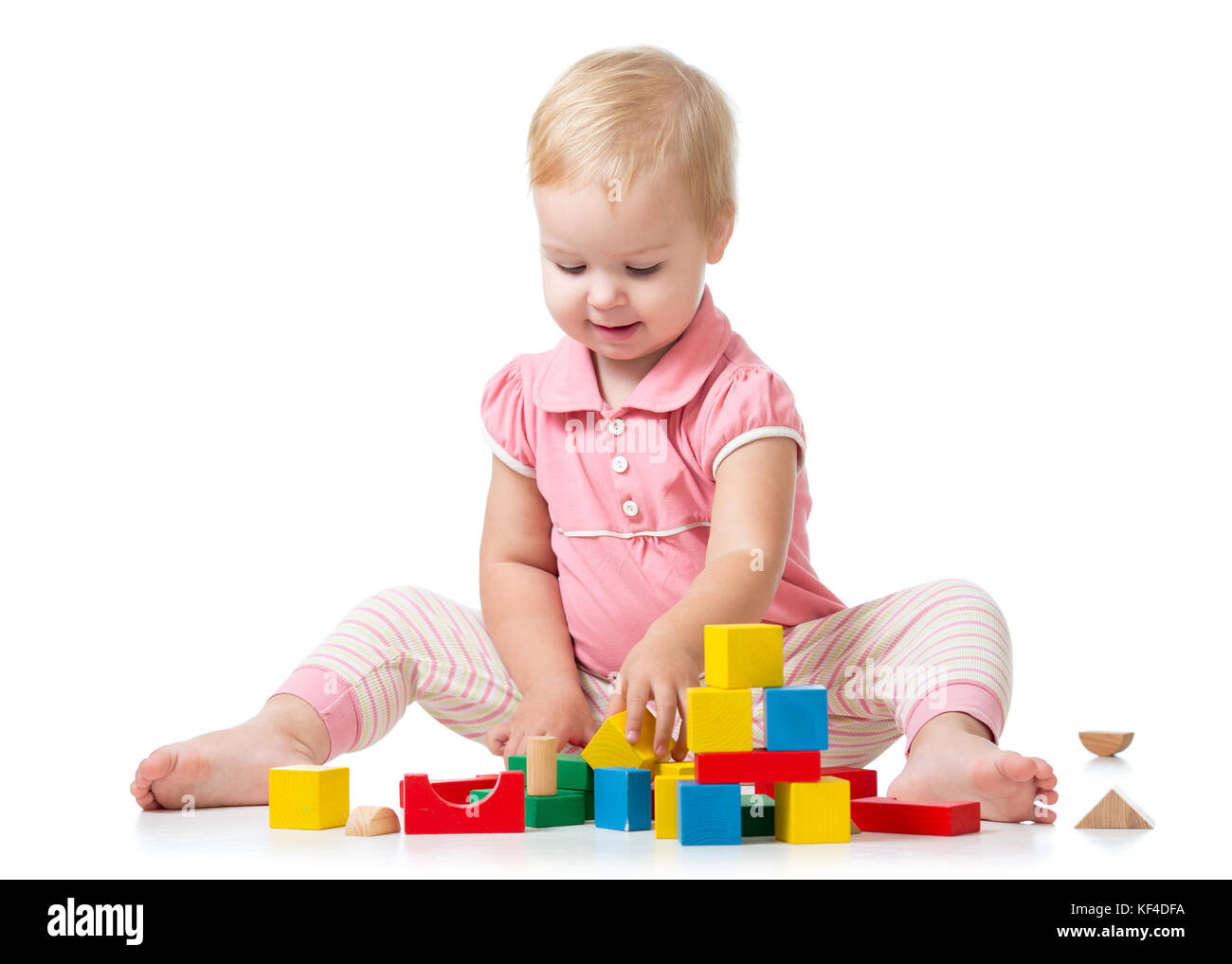 Kid playing with wooden block toys. Baby girl building castle using cubes. Educational toys for preschool and kindergarten child. Stock Photo
