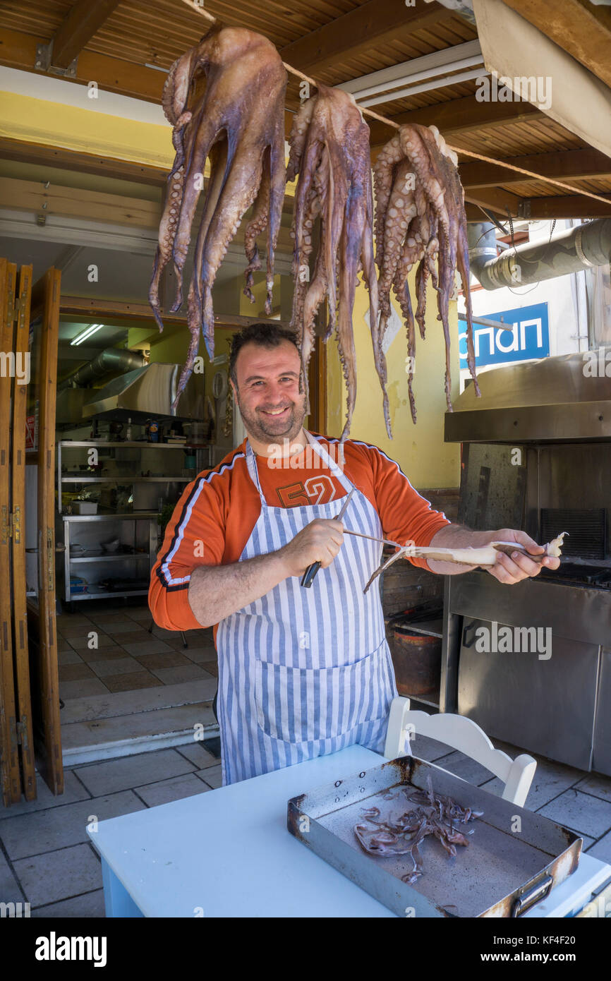 Local man clening a octopus at fish restaurant, harbour of Naxos-town, Naxos island, Cyclades, Aegean, Greece Stock Photo