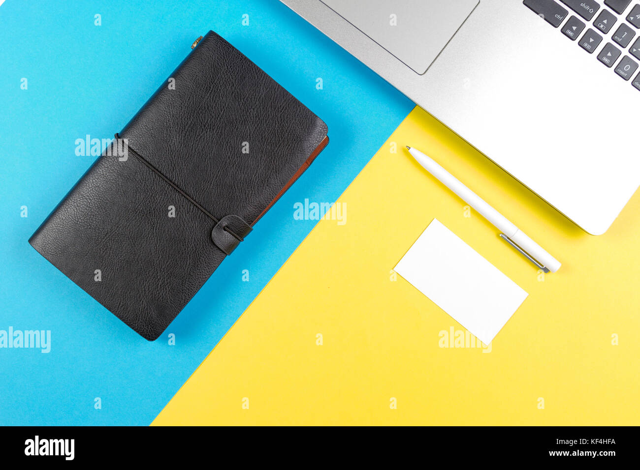 Top view of laptop computer, paper travel notebook with blank card and