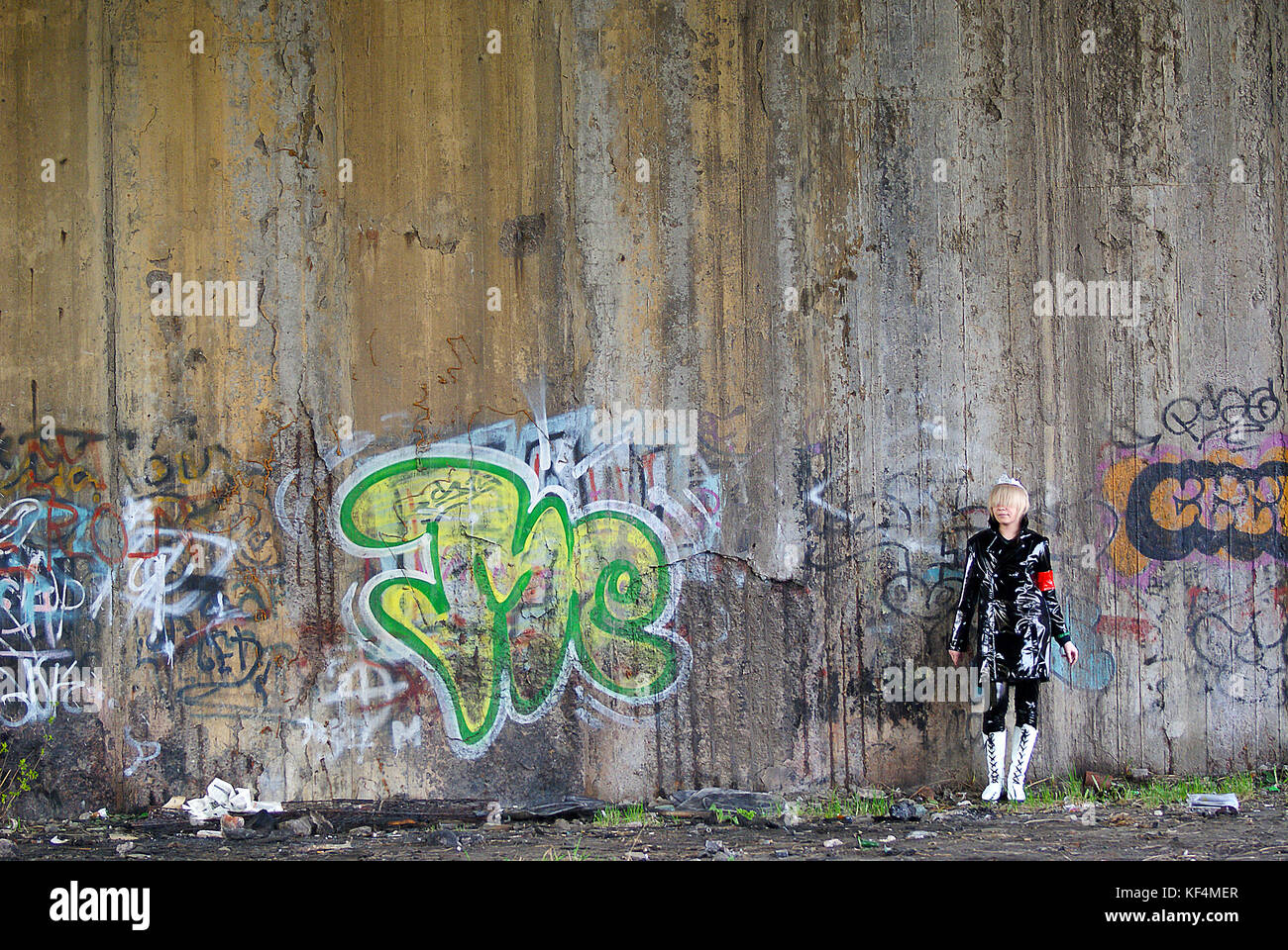 A girl in a leather coat posing against graffiti background Stock Photo