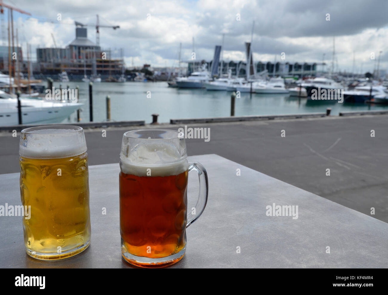Beers on a table overlooking Viaduct Harbour at Headquarters bar in Auckland, New Zealand Stock