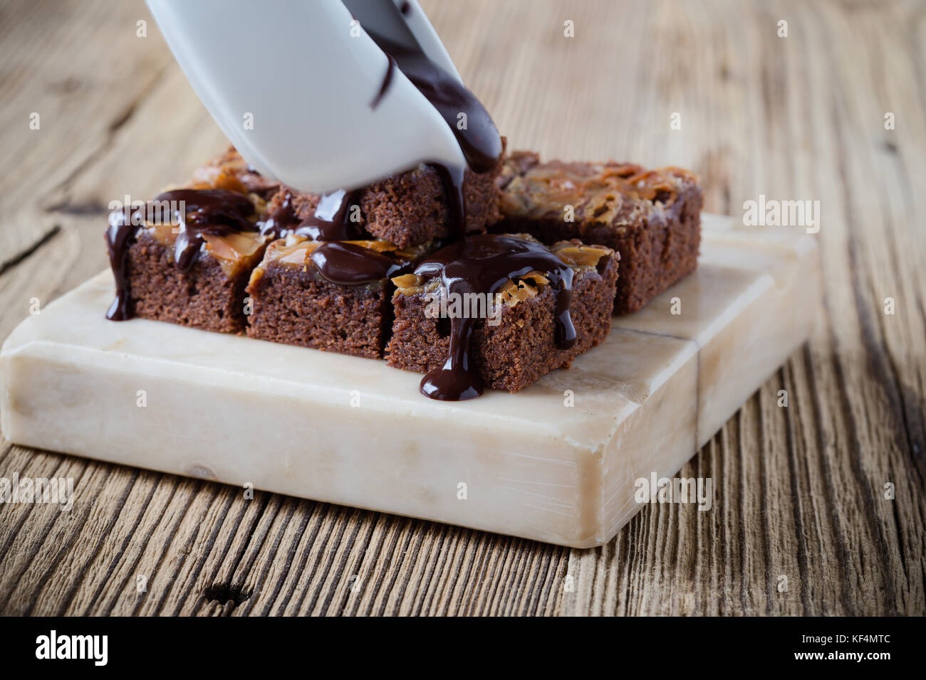 Caramel chocolate brownies with dark chocolate ganache served on marble stand Stock Photo Alamy