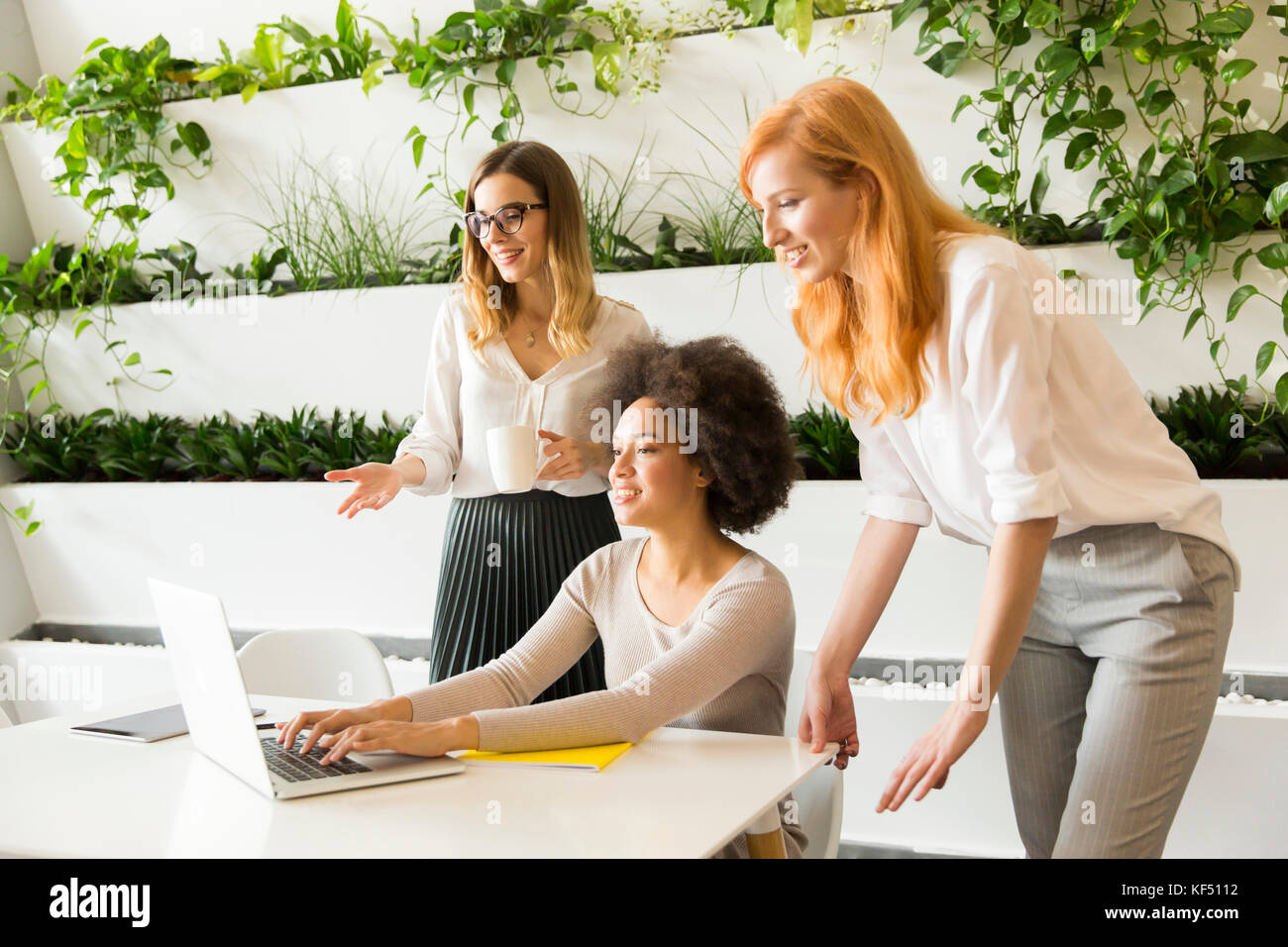 Three young businesswomen working together in the office Stock Photo ...
