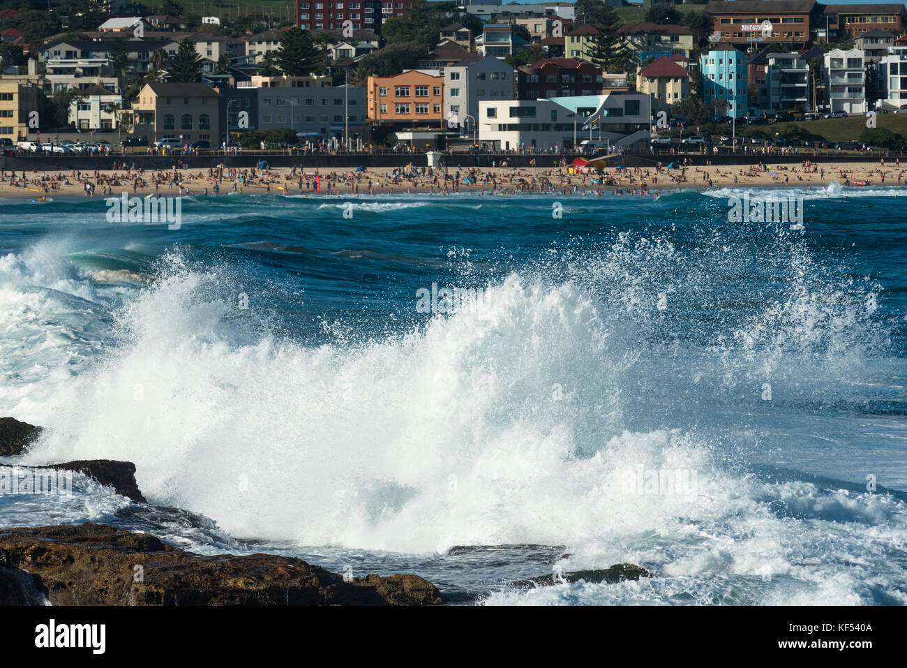 Waves hit the rocks with Bondi Beach in the distance. Sydney, New South