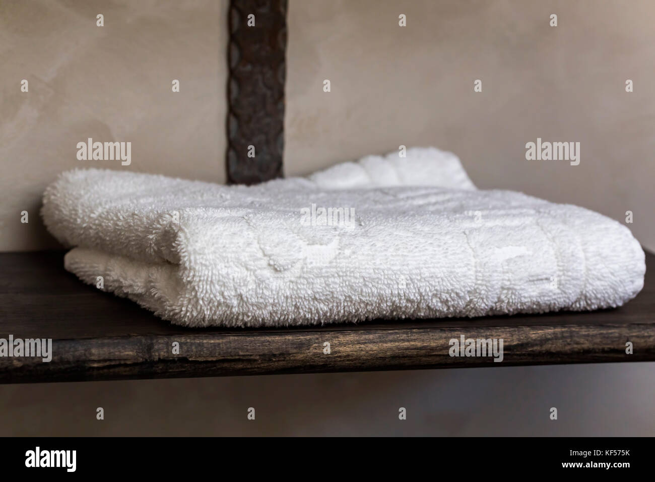 One white towel on wooden support Stock Photo