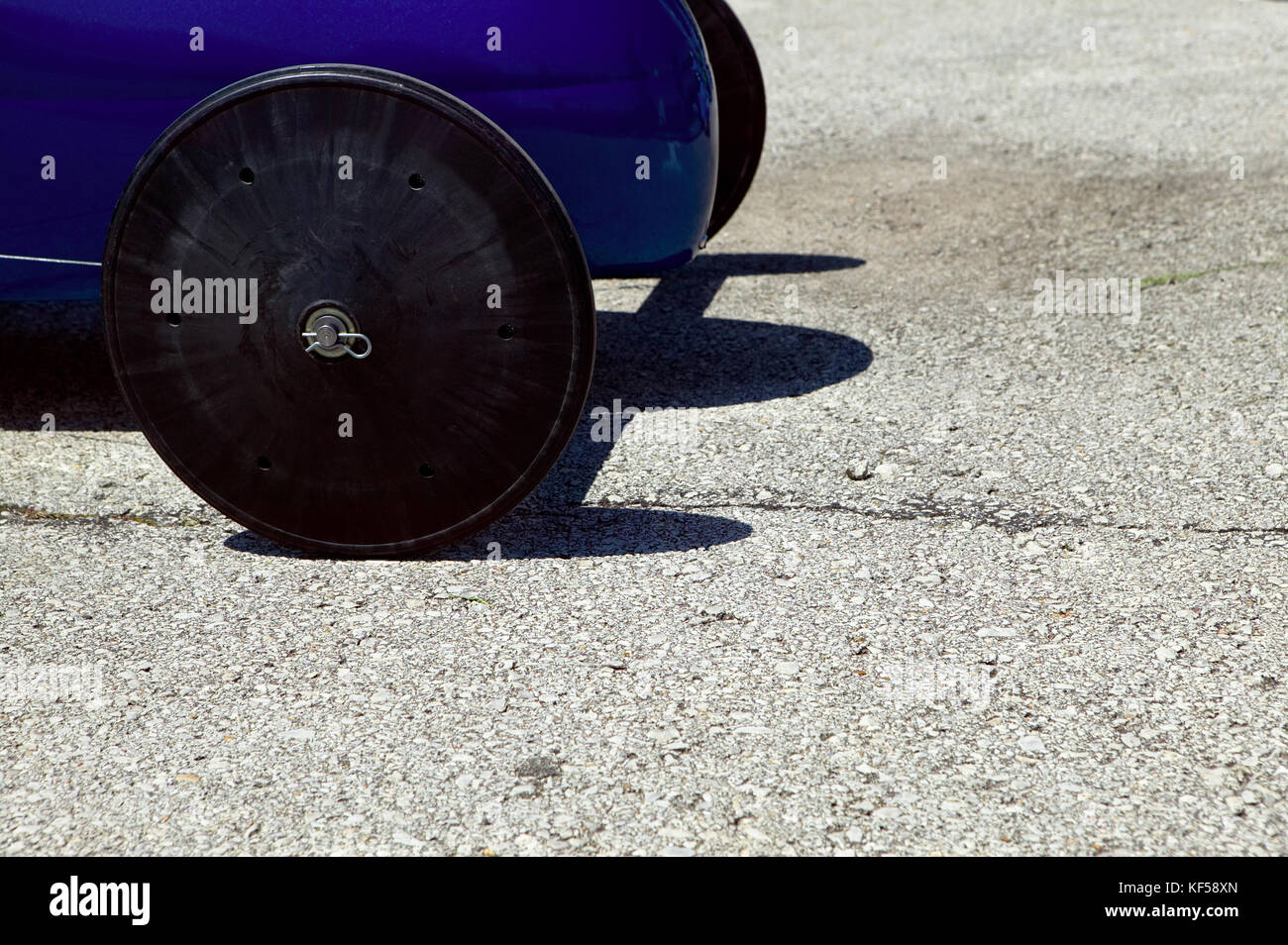 Front wheels of a blue soap box derby car with copy space waiting to