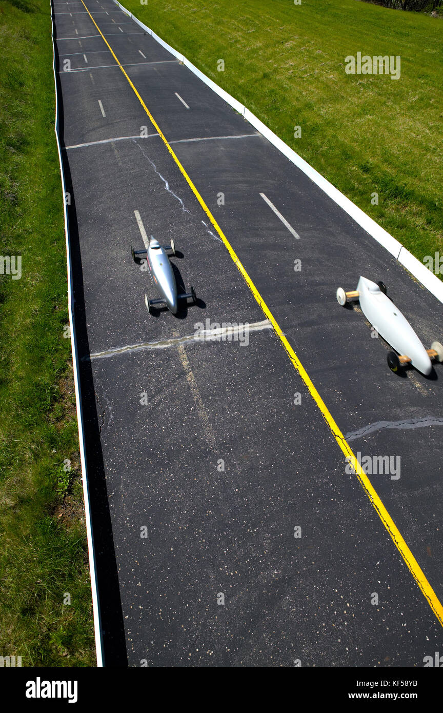 Two cars competing in a Soap Box Derby for young people in unpowered