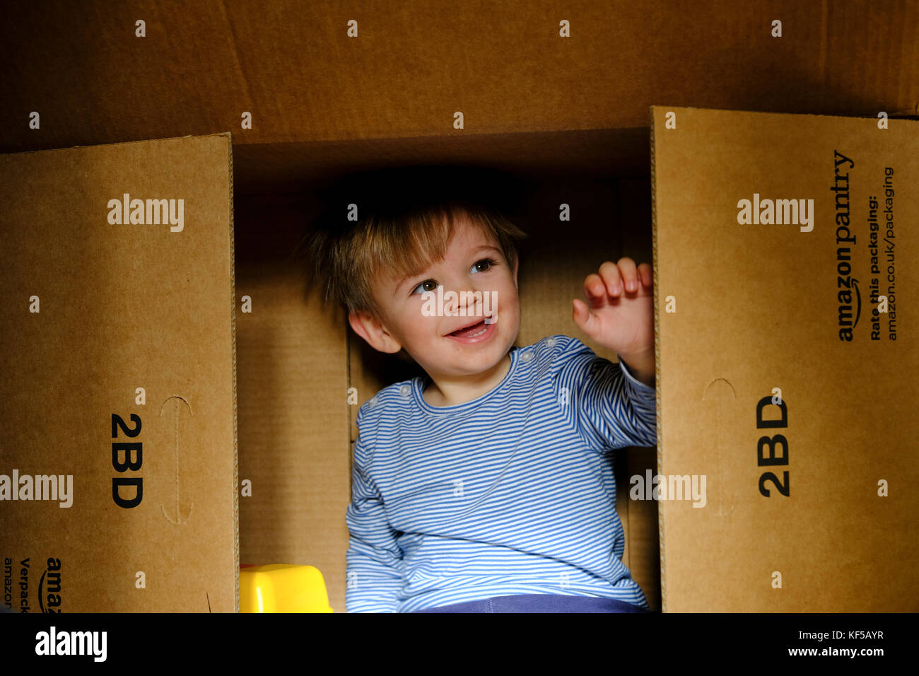 A toddler boy playing inside a large cardboard delivery box from Amazon  Stock Photo - Alamy
