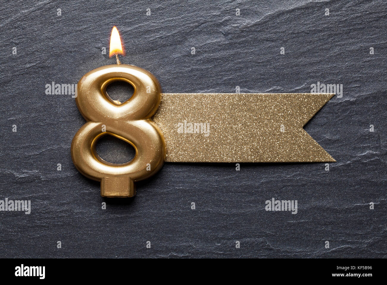 Gold number 8 celebration candle with glitter label Stock Photo - Alamy