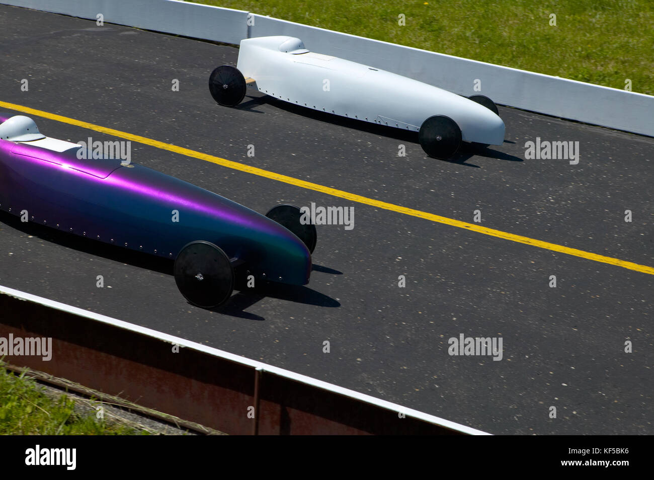 Two cars competing in an American soap box derby race between two unpowered vehicles raced off a ramp in speed trials Stock Photo