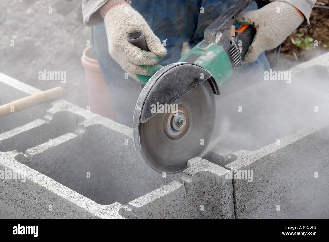 Construction worker making cuttings in concrete blocks for