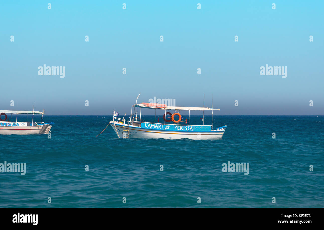 Santorini Island, Greece - July 19, 2012: Boats, commonly known as water taxi, carry tourists from Kamari Beach to Perissa. Stock Photo