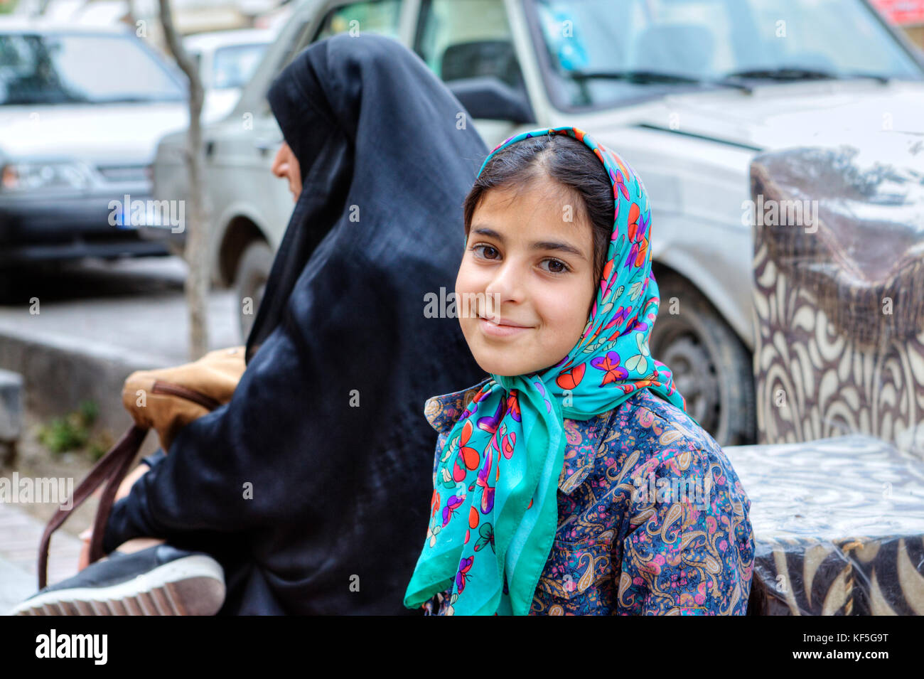 Shiraz, Iran - 19 april, 2017: Mature woman and a girl about 8 years old sat down to rest on a city street. Stock Photo