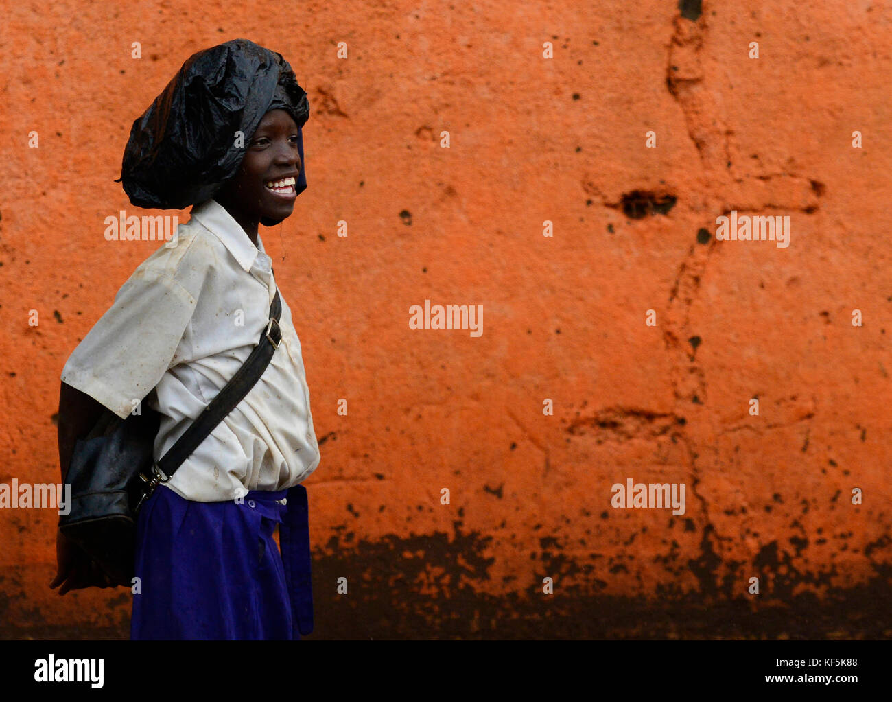 A Tanzanian school girl walking in the rain. Stock Photo