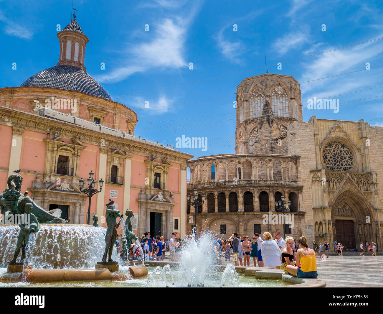 Turia fountain in la Plaza de la Virgen situated by the Cathedral (right) and  Basilica Virgen de los Desamparados (left), Valencia, Spain Stock Photo