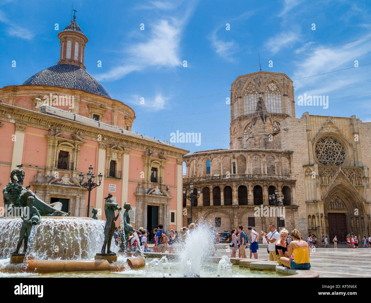 Tourists sightseeing by Turia fountain in la Plaza de la Virgen situated by the Cathedral (right) and  Basilica Virgen de los Desamparados, Valencia Stock Photo