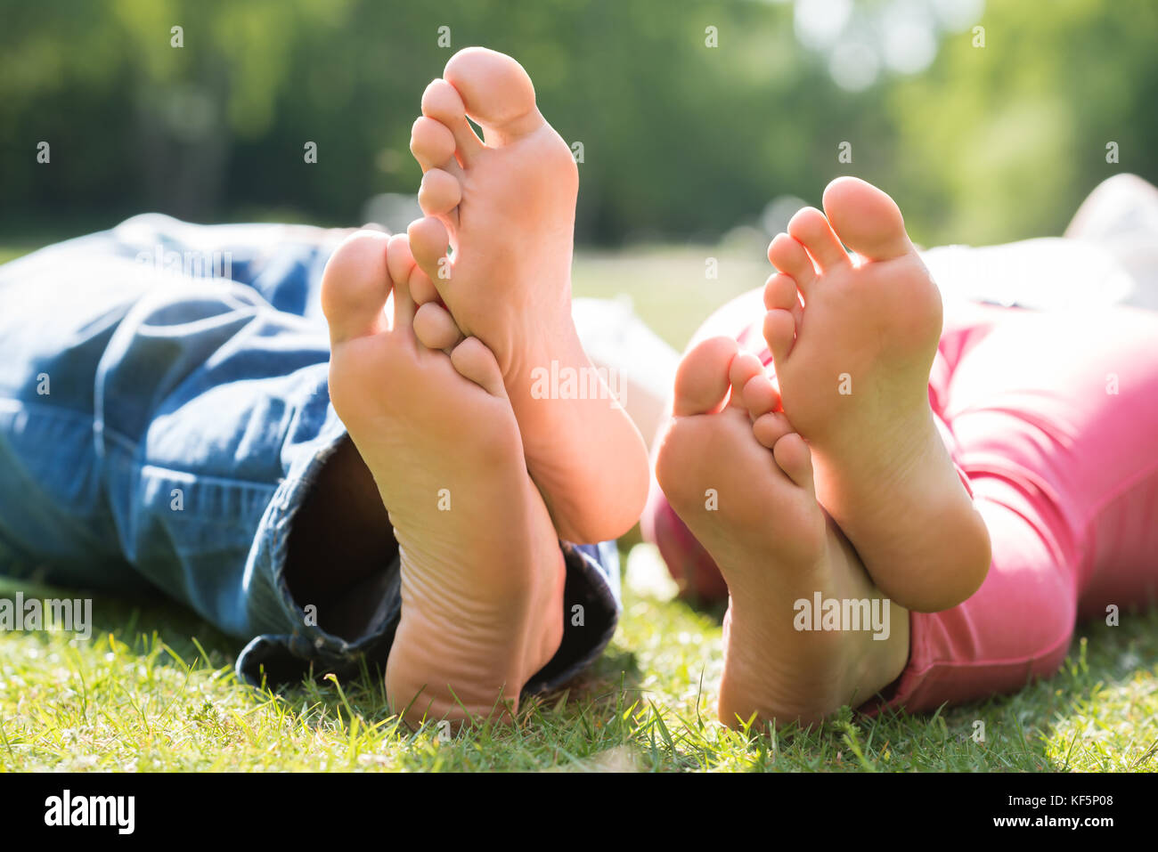 Closeup Of Couple Feet While Lying On Grass At Park Stock Photo Alamy