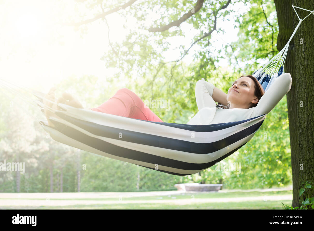 Young Happy Woman Relaxing In Hammock At Garden Stock Photo