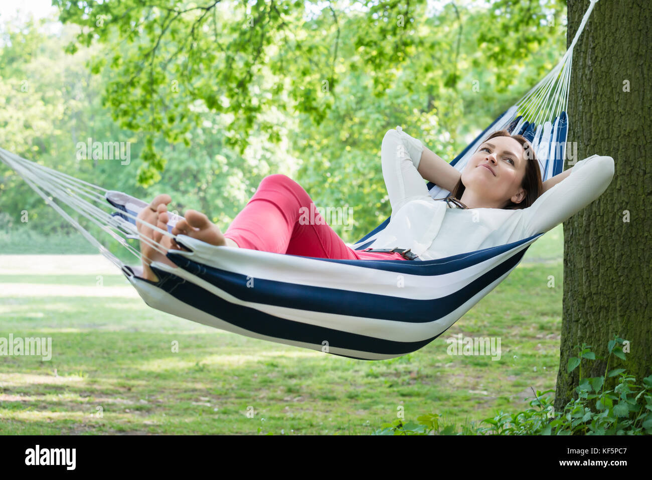 Young Happy Woman Relaxing In Hammock At Garden Stock Photo