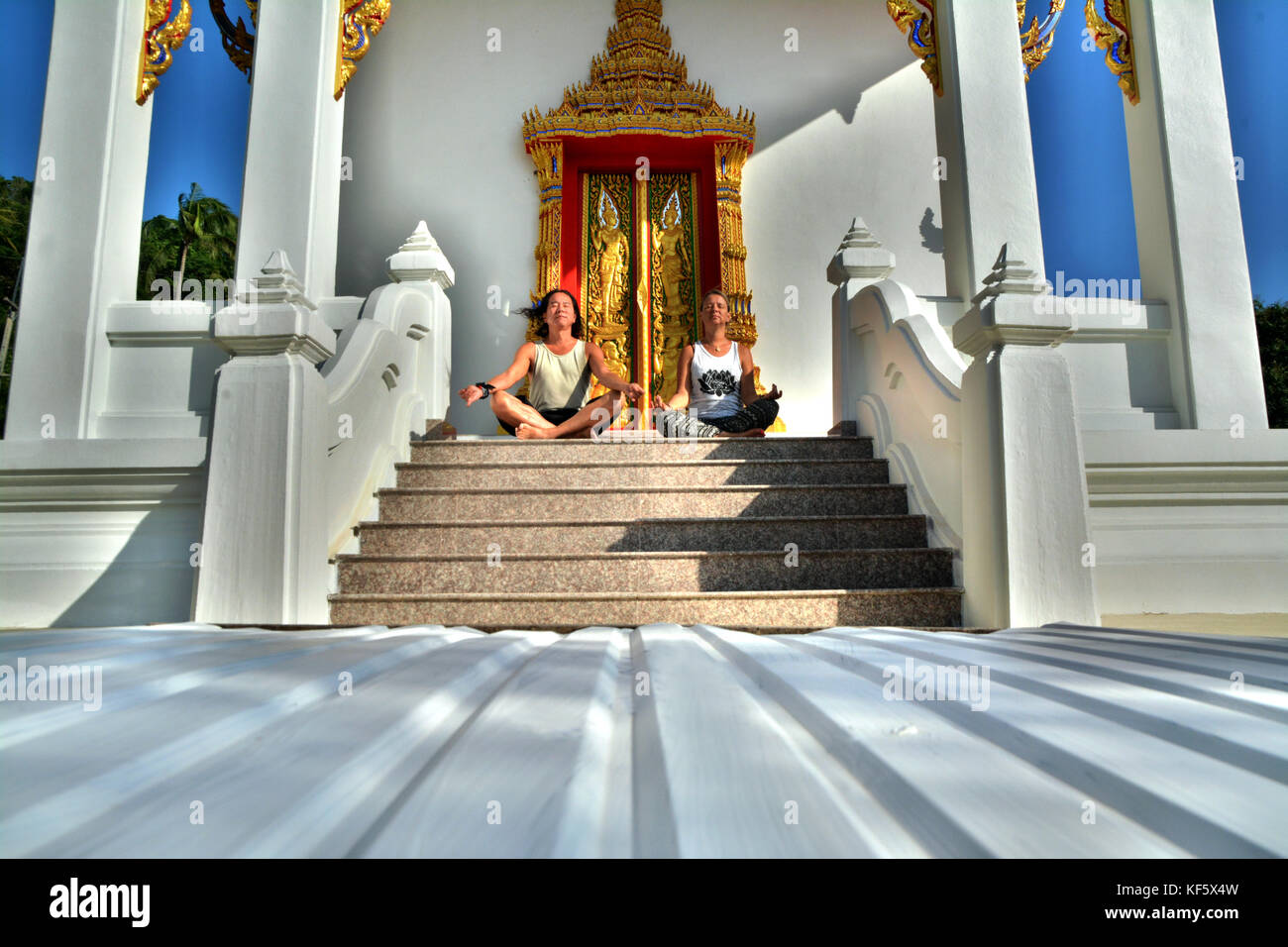 Man and woman focus on meditation at a  beautiful monastery in Ko Tao, Thailand Stock Photo